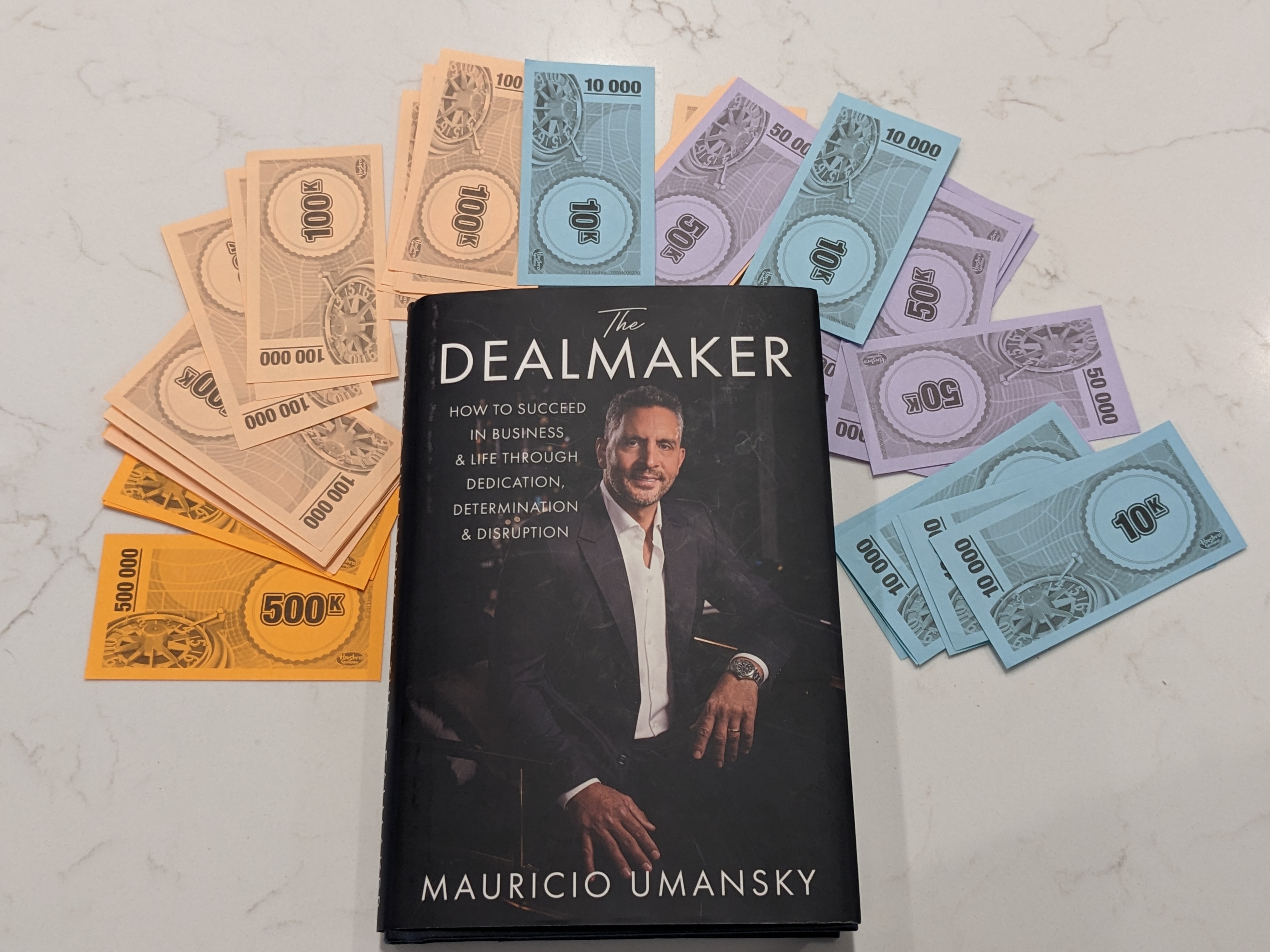 The Dealmaker book surrounded by Monopoly money